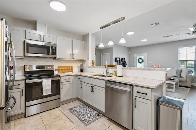 309 Allie Ln, Luling, LA 70070 - kitchen with open floor plan, a peninsula, backsplash, appliances with stainless steel finishes, and a sink