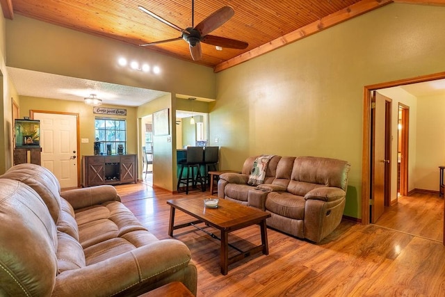 living area featuring light wood finished floors, wooden ceiling, ceiling fan, and vaulted ceiling