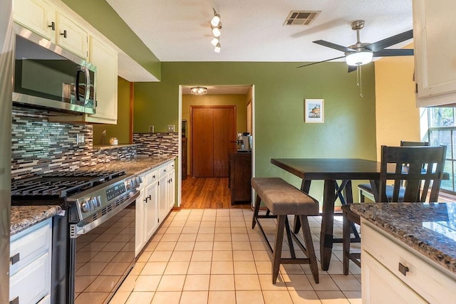 kitchen featuring tasteful backsplash, visible vents, white cabinetry, and stainless steel appliances