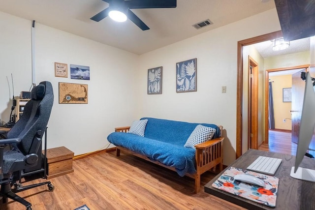 home office with wood finished floors, baseboards, a ceiling fan, and visible vents