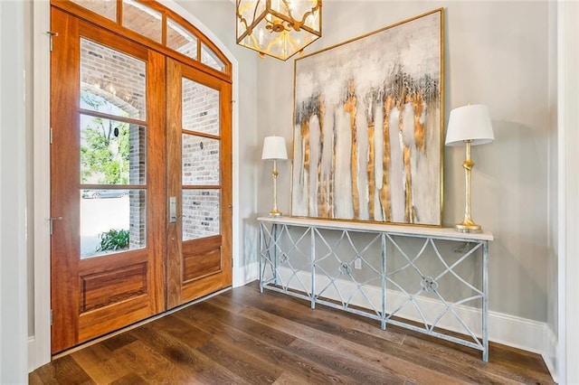 foyer with french doors, dark wood-style flooring, baseboards, and an inviting chandelier