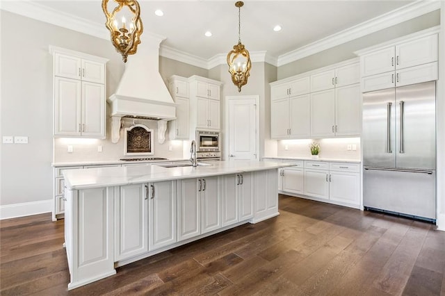 kitchen with a chandelier, custom exhaust hood, built in appliances, and white cabinets