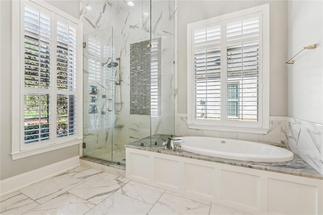 full bath featuring a marble finish shower, marble finish floor, a garden tub, and a healthy amount of sunlight