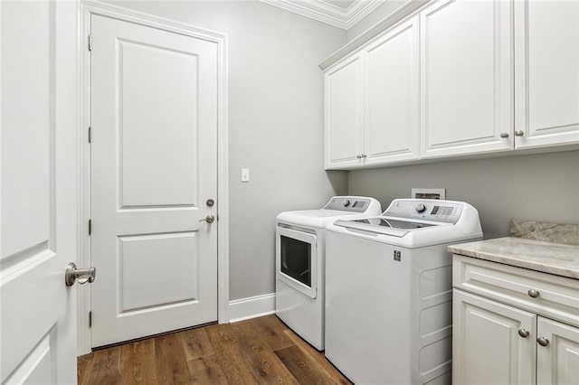 clothes washing area featuring baseboards, ornamental molding, dark wood-style floors, cabinet space, and washing machine and dryer