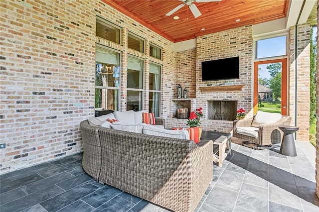 view of patio / terrace featuring an outdoor living space with a fireplace and a ceiling fan