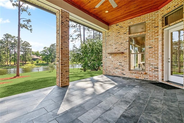 view of patio with a water view and a ceiling fan