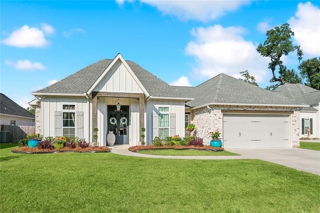 view of front of property with central AC unit, concrete driveway, a front lawn, an attached garage, and roof with shingles