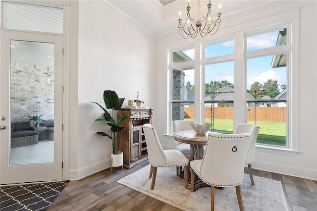 4073 Oak Bend Ln, Madisonville, LA 70447 - dining area with wood finished floors, a chandelier, crown molding, baseboards, and a raised ceiling