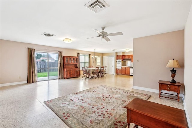 6505 Carmen St, Metairie, LA 70003 - living room with baseboards, visible vents, ceiling fan with notable chandelier, and light speckled floor