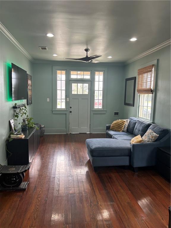 living area featuring dark wood-style floors, ornamental molding, ceiling fan, baseboards, and recessed lighting