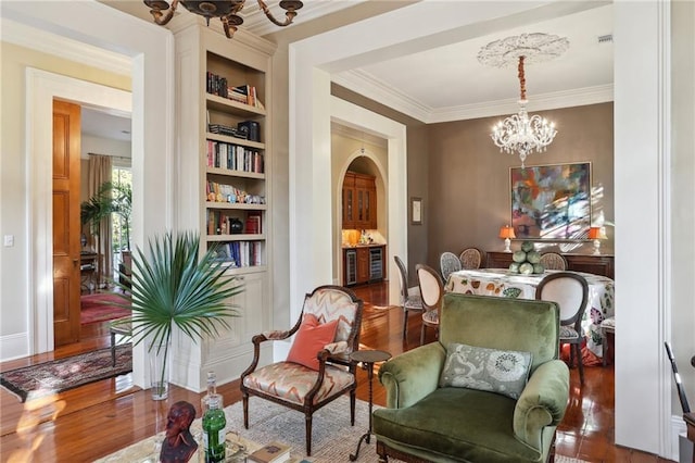 3611 Carondelet St, New Orleans, LA 70115 - sitting room featuring built in features, ornamental molding, wood finished floors, and a notable chandelier