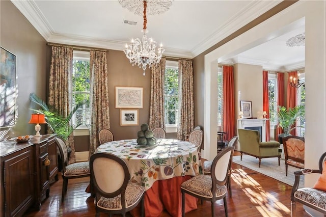 3611 Carondelet St, New Orleans, LA 70115 - dining area with a notable chandelier, ornamental molding, visible vents, and dark wood-type flooring