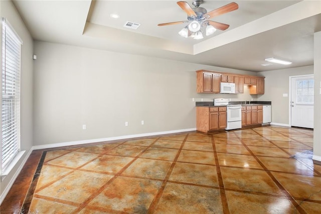 48351 Woodhaven Rd, Tickfaw, LA 70466 - kitchen with baseboards, white appliances, dark countertops, visible vents, and a tray ceiling
