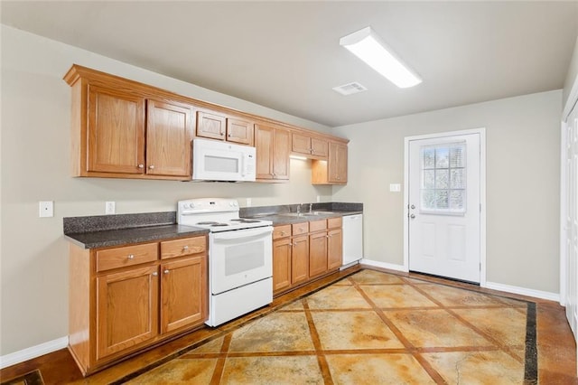 48351 Woodhaven Rd, Tickfaw, LA 70466 - kitchen featuring visible vents, baseboards, a sink, dark countertops, and white appliances