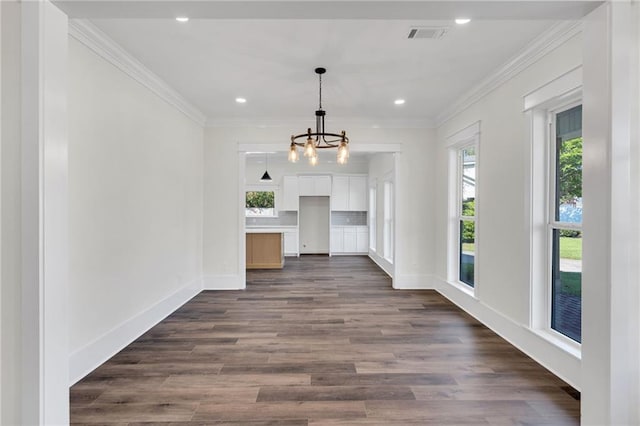 unfurnished dining area with crown molding, recessed lighting, and an inviting chandelier