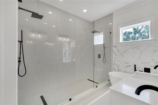 full bath featuring a freestanding tub, vanity, tile walls, and a marble finish shower