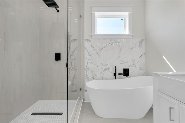 full bathroom featuring tile walls, a walk in shower, and a freestanding tub