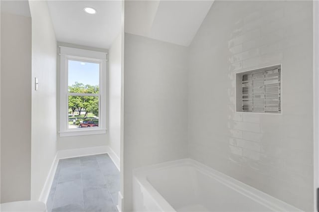 bathroom featuring toilet, baseboards, tile patterned flooring, and lofted ceiling