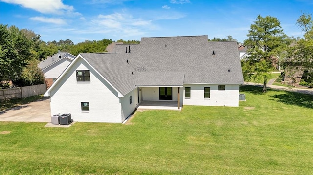 rear view of house featuring a patio area, fence, cooling unit, and a lawn