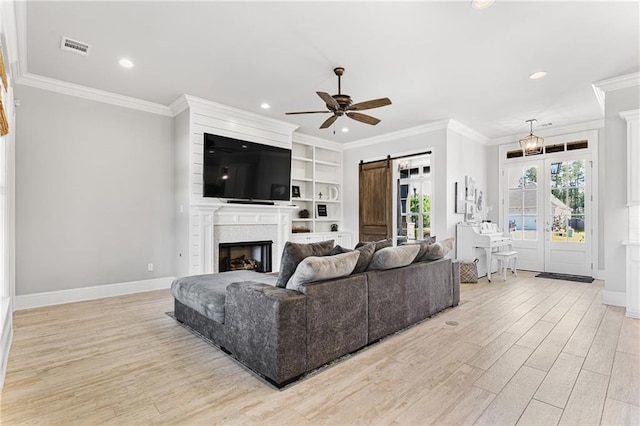 living area with recessed lighting, a barn door, visible vents, ceiling fan, and light wood finished floors