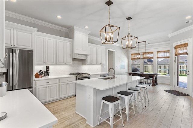 kitchen featuring a sink, light countertops, a kitchen breakfast bar, and stainless steel appliances
