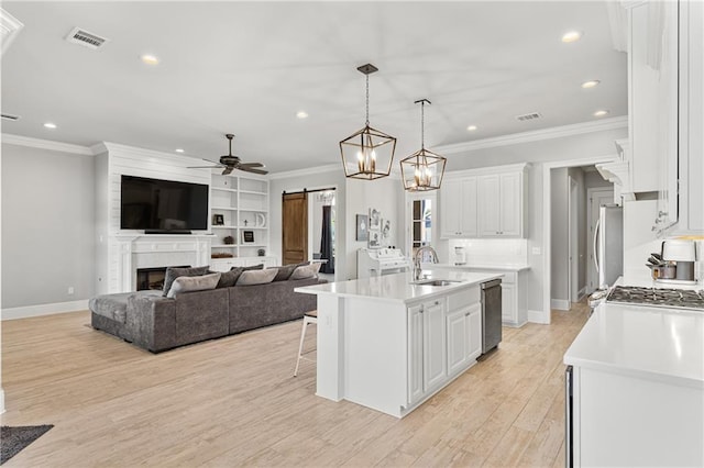 kitchen with recessed lighting, a barn door, visible vents, stainless steel dishwasher, and a sink