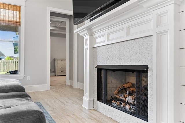 bedroom featuring baseboards, wood finished floors, and a fireplace