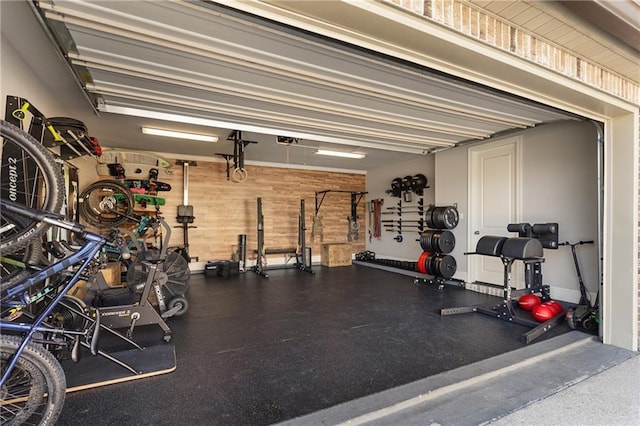 exercise room with a garage and wooden walls
