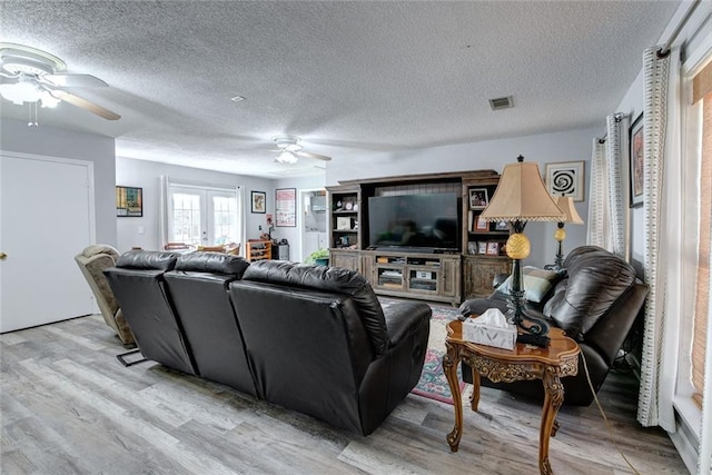 232 Chateau Dr, Slidell, LA 70460 - living room featuring a ceiling fan, light wood-type flooring, and a textured ceiling