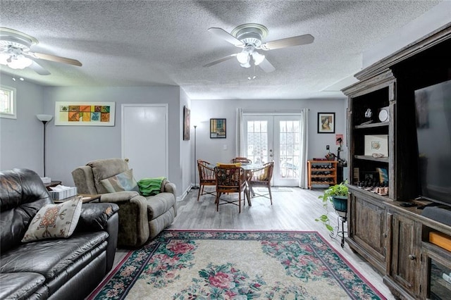 232 Chateau Dr, Slidell, LA 70460 - living area with a ceiling fan, french doors, light wood-type flooring, healthy amount of natural light, and a textured ceiling