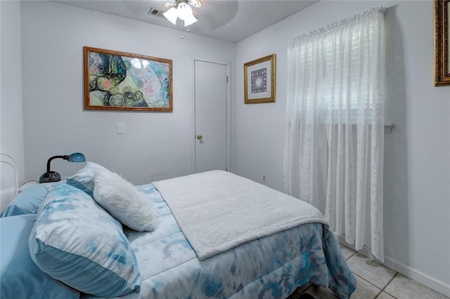 232 Chateau Dr, Slidell, LA 70460 - bedroom featuring light tile patterned floors, a textured ceiling, and a ceiling fan