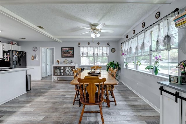 232 Chateau Dr, Slidell, LA 70460 - dining room featuring ceiling fan, a textured ceiling, and light wood-style flooring