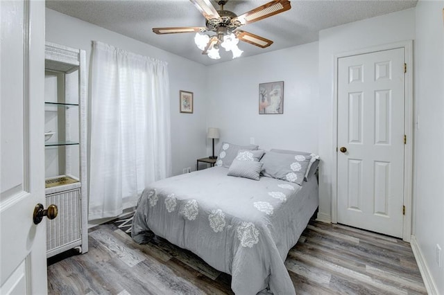 232 Chateau Dr, Slidell, LA 70460 - bedroom featuring wood finished floors, ceiling fan, and a textured ceiling