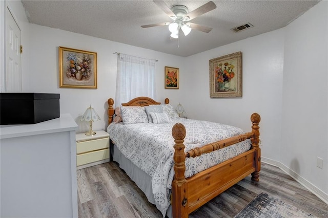 232 Chateau Dr, Slidell, LA 70460 - bedroom featuring a textured ceiling, wood finished floors, and ceiling fan