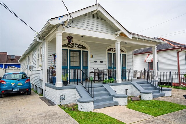 8632 Apple St, New Orleans, LA 70118 - shotgun-style home featuring a porch and fence