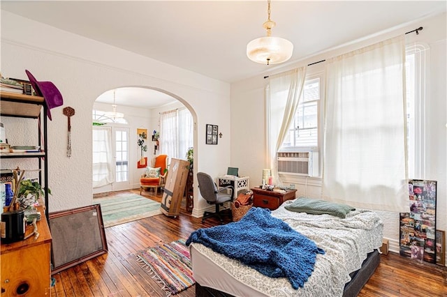8632 Apple St, New Orleans, LA 70118 - bedroom featuring arched walkways, cooling unit, and hardwood / wood-style floors
