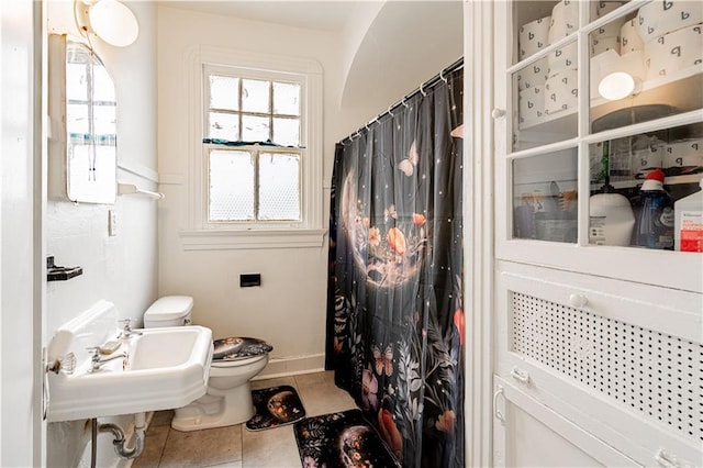 8632 Apple St, New Orleans, LA 70118 - bathroom featuring a sink, tile patterned flooring, toilet, baseboards, and curtained shower