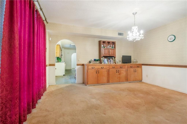 1805 13th Ave, Franklinton, LA 70438 - dining room with arched walkways, light colored carpet, wallpapered walls, a chandelier, and baseboards