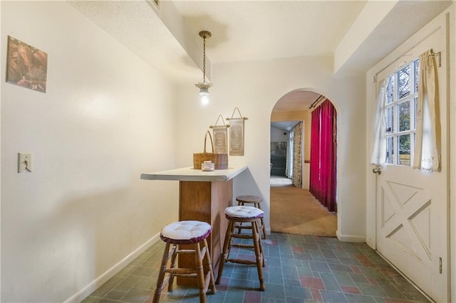 1805 13th Ave, Franklinton, LA 70438 - dining room featuring arched walkways, baseboards, and dark carpet