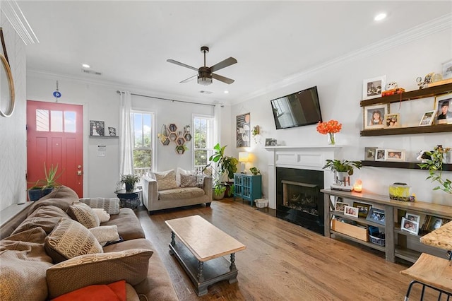 6038 Orleans Ave, New Orleans, LA 70124 - living room featuring a fireplace, wood finished floors, ornamental molding, and ceiling fan
