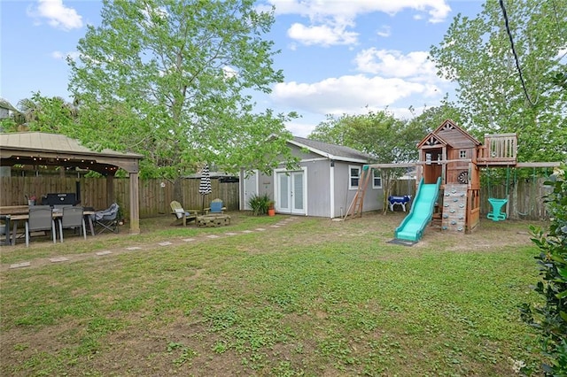 6038 Orleans Ave, New Orleans, LA 70124 - view of yard with a fenced backyard, an outdoor structure, a playground, a gazebo, and french doors