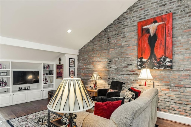 living area featuring wood finished floors, brick wall, and vaulted ceiling