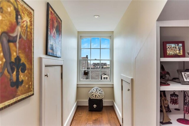 hallway featuring baseboards and wood finished floors