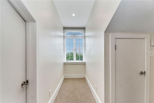corridor with carpet floors and baseboards