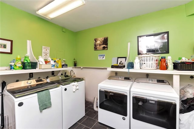 laundry area featuring washing machine and clothes dryer, dark tile patterned floors, and laundry area