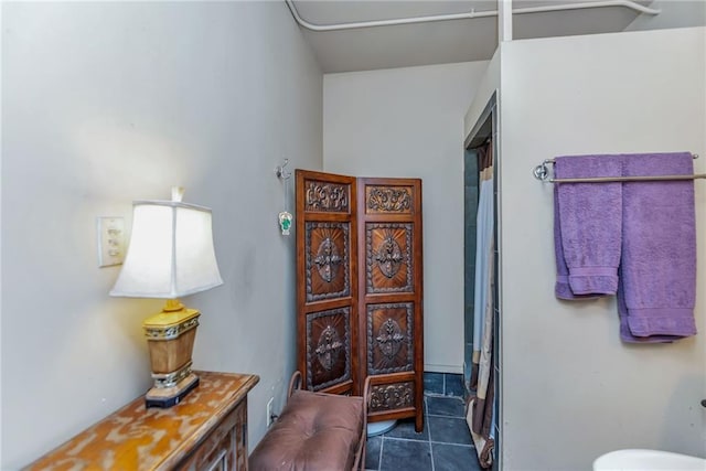 bathroom featuring a shower with shower curtain, tile patterned floors, and toilet