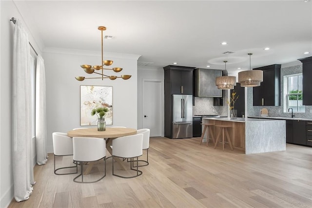 kitchen featuring high end fridge, a notable chandelier, light countertops, backsplash, and ornamental molding