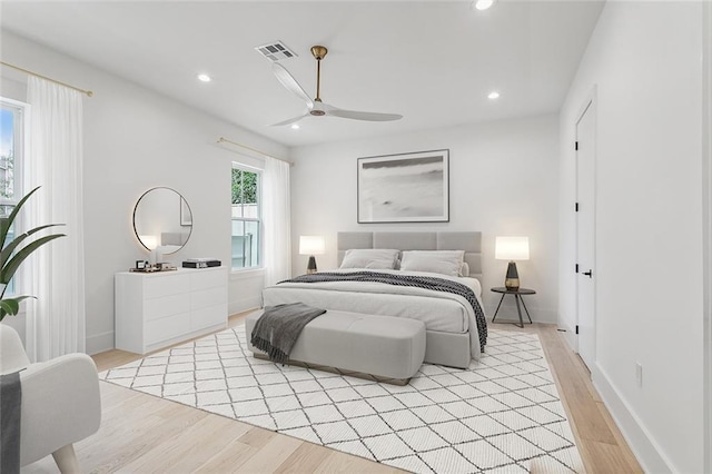 bedroom featuring visible vents, baseboards, recessed lighting, light wood-type flooring, and a ceiling fan