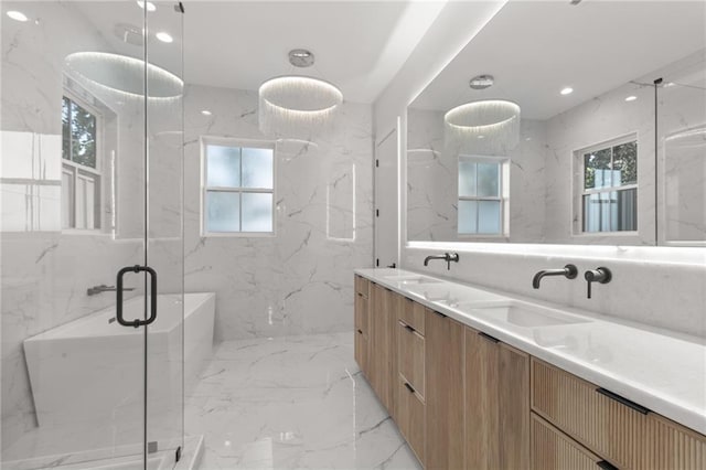 full bathroom with a wealth of natural light, a sink, and marble finish floor
