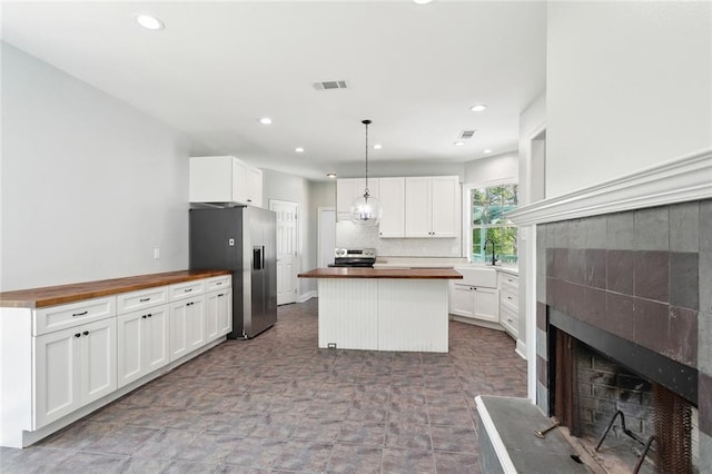 42 Green Hills Dr, Covington, LA 70435 - kitchen featuring wooden counters, a fireplace with raised hearth, visible vents, stainless steel appliances, and a sink